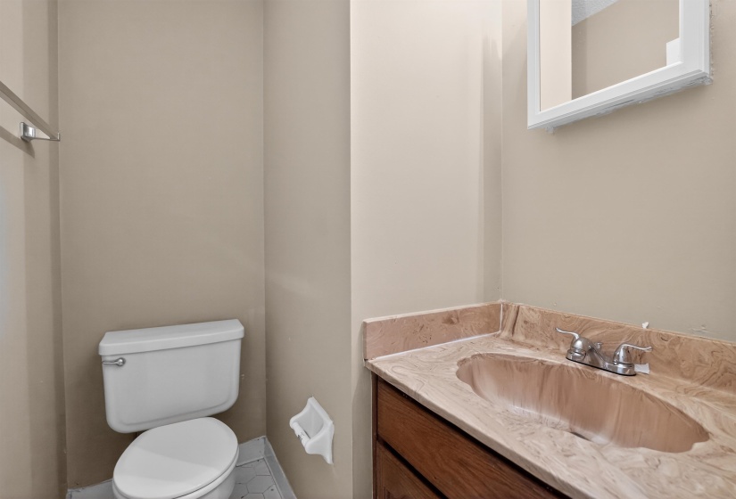 Bathroom vanity with a built-in sink, stone-finish countertop, wood-finish cabinetry, and chrome fixtures