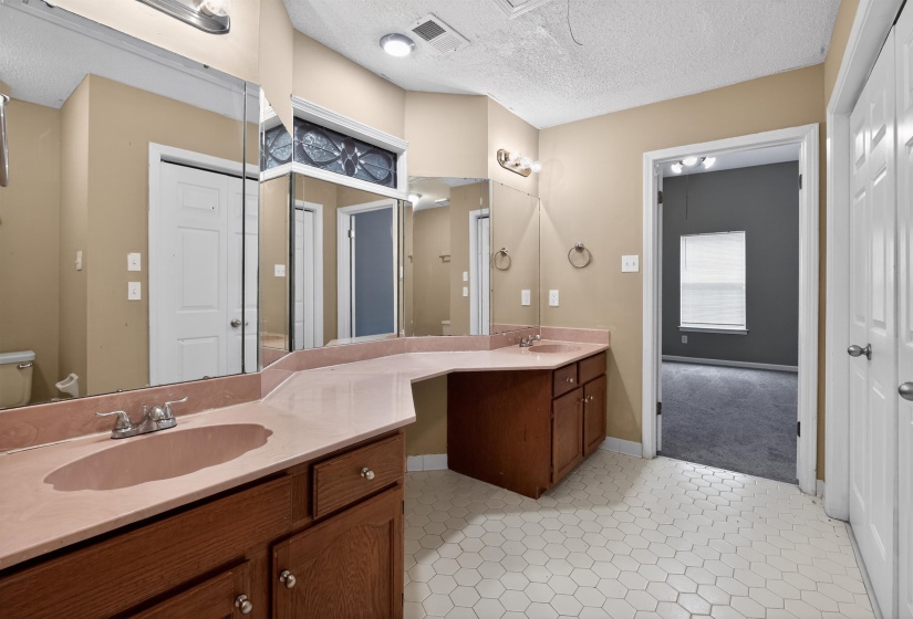 Bathroom featuring a double vanity with integrated sinks and a spacious countertop