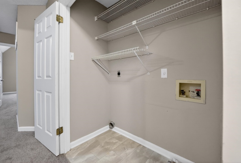 Utility closet featuring wire shelving, a laundry hookup box, and a floor vent