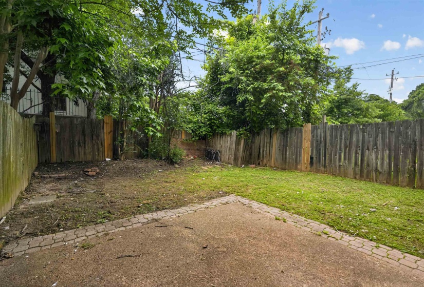 Patio area featuring paver-stone edging and a natural grass section