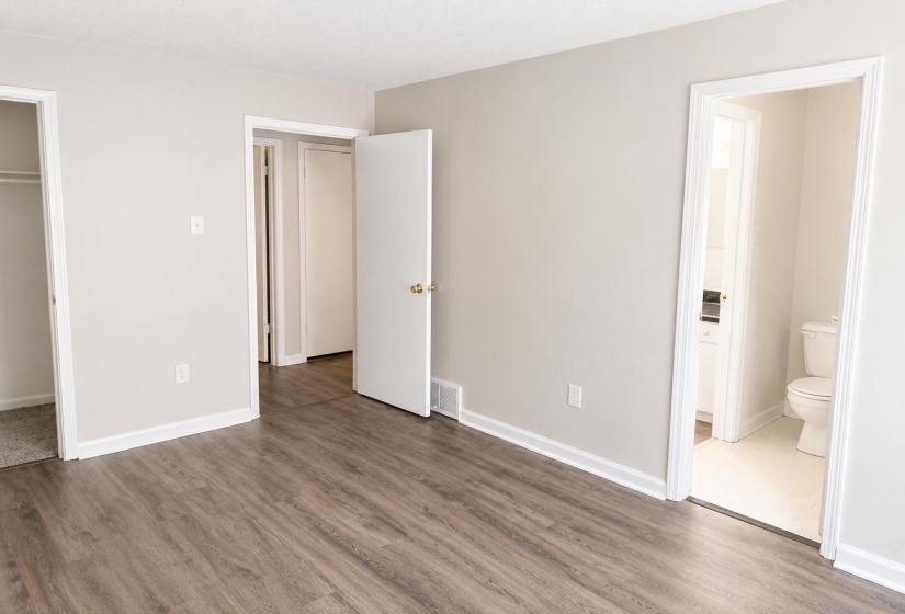 Wood-finish flooring throughout the room, complemented by neutral wall paint and white baseboards