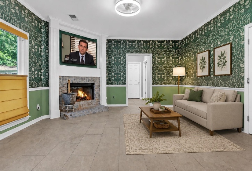 Living area featuring a stone fireplace with a white mantel, ceiling fan with integrated lighting, and tile flooring