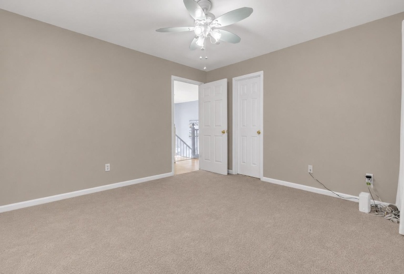Carpeted room with neutral tone walls and white baseboards