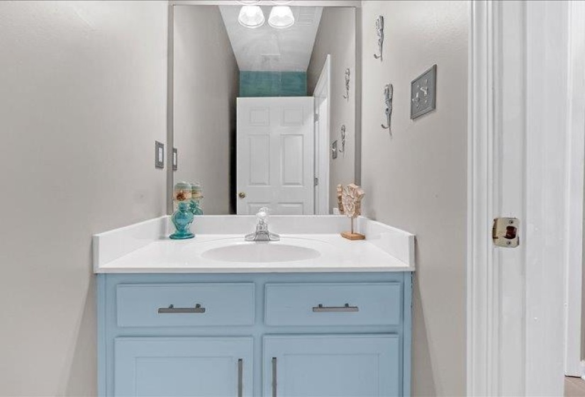 Bathroom vanity featuring a light blue cabinet base, white countertop, and an integrated sink with a chrome faucet