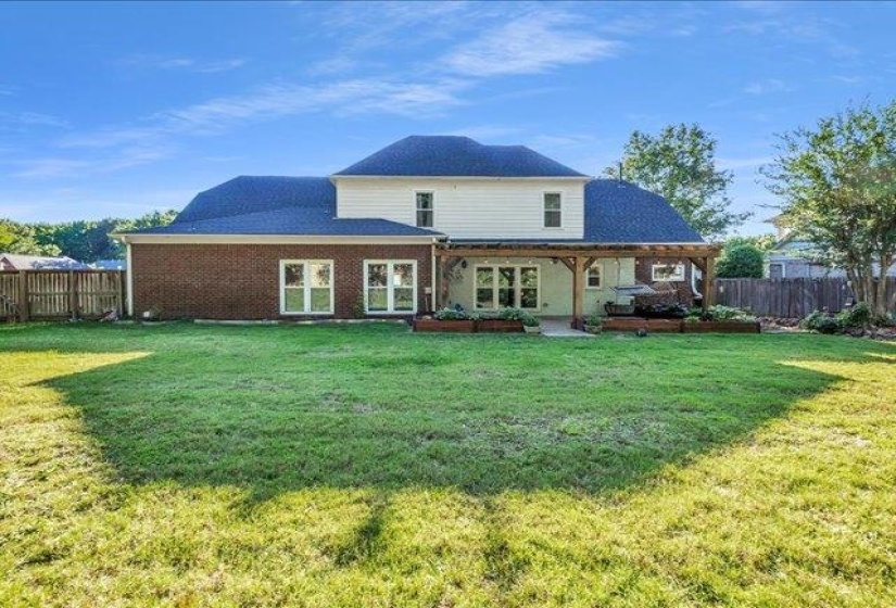 Expansive green lawn with a privacy fence