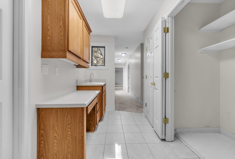 Utility space featuring white tile flooring and overhead lighting