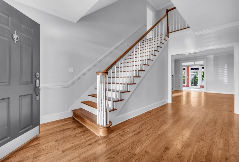 Entryway featuring a grand staircase with wood treads and white balusters