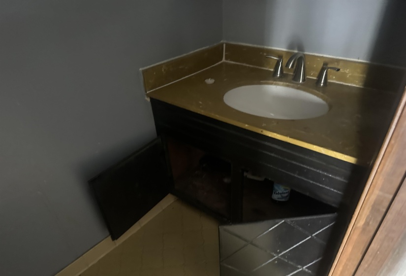 Vanity with an integrated sink, a gold-finish countertop, and a chrome faucet