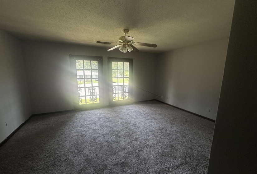Spacious room featuring broadloom carpeting and a ceiling fan