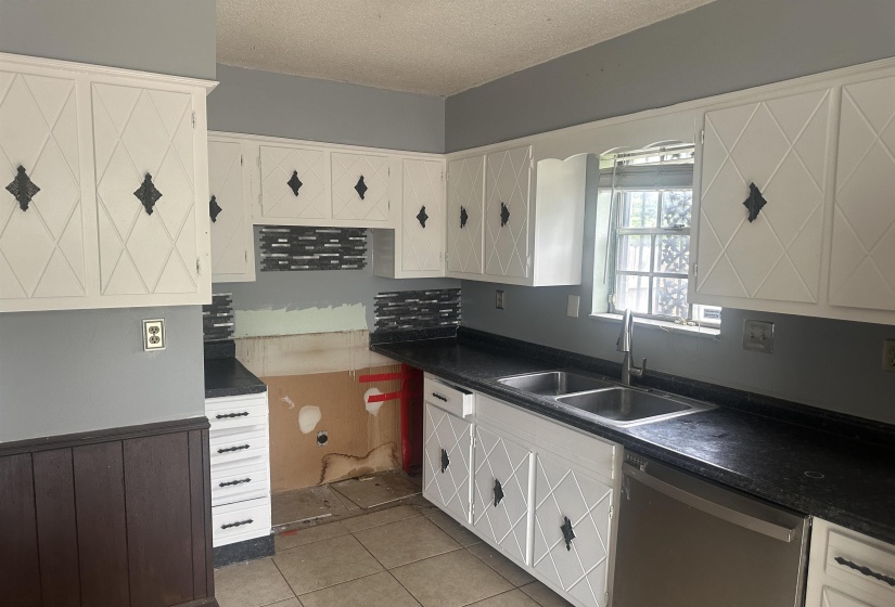 Kitchen featuring white cabinetry with diamond-patterned door details and decorative black hardware