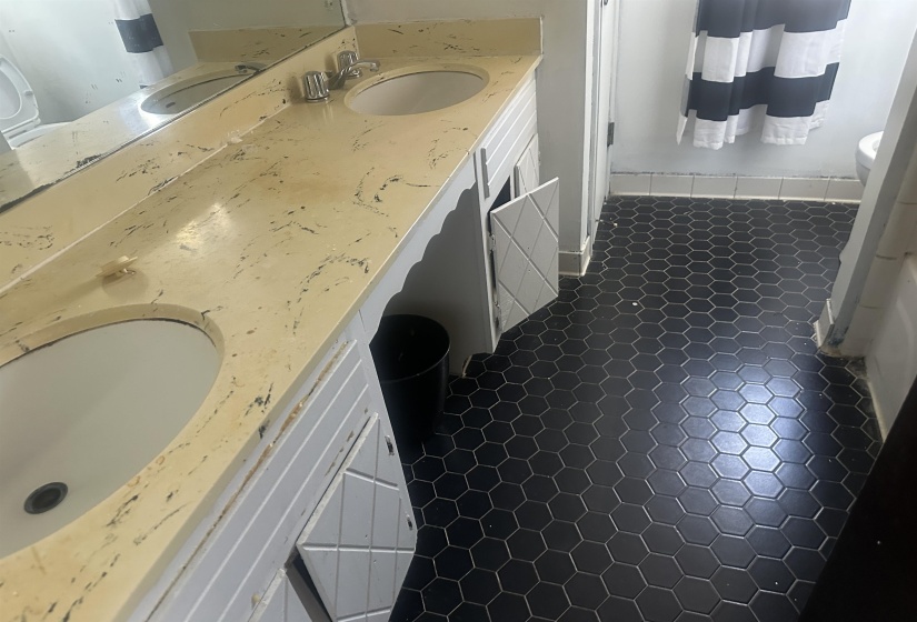 Dual vanity with integrated sinks, a light-toned countertop, and chrome fixtures