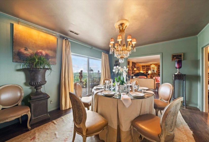 Dining space with a chandelier, wood finished floors, and crown molding
