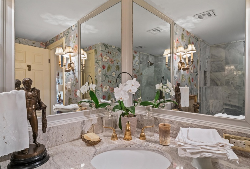 Bathroom featuring wallpapered walls, a walk in shower, a chandelier, and vanity