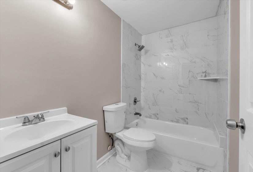 Bathroom featuring a white vanity with integrated sink, chrome-finish faucet, and two-door cabinet storage