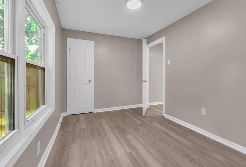 Room featuring light wood-finish flooring, neutral wall paint, and bright white trim