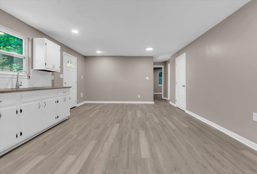 Open-concept living space featuring wood-finish flooring, recessed lighting, and neutral wall tones