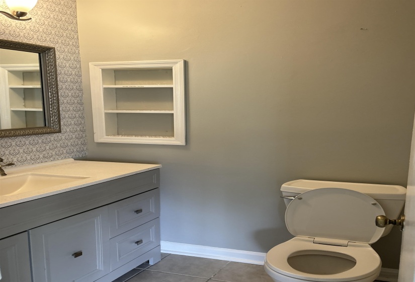 Vanity with integrated sink and chrome faucet, set against a patterned accent wall