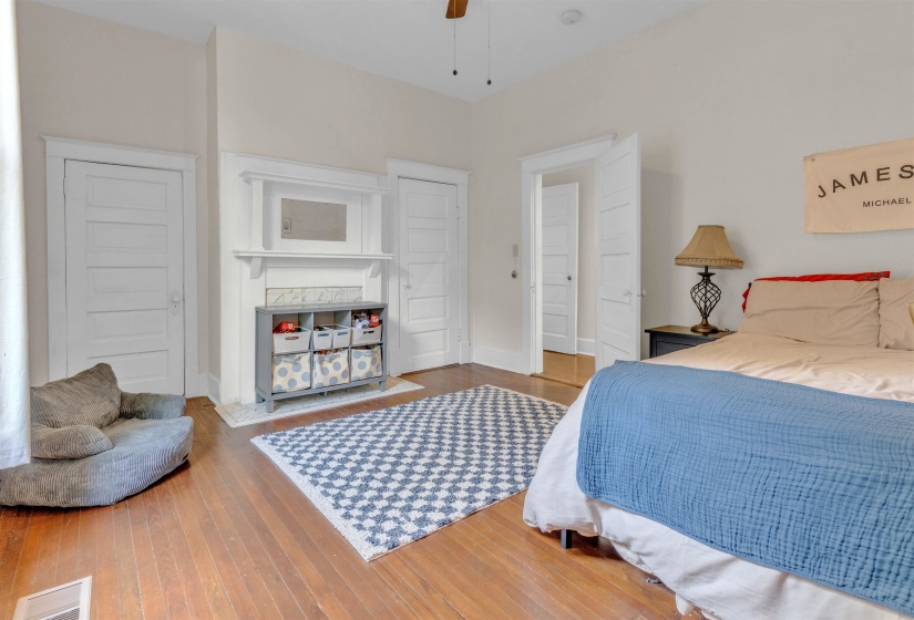 Hardwood flooring throughout featuring a decorative fireplace with white mantel and tiled surround