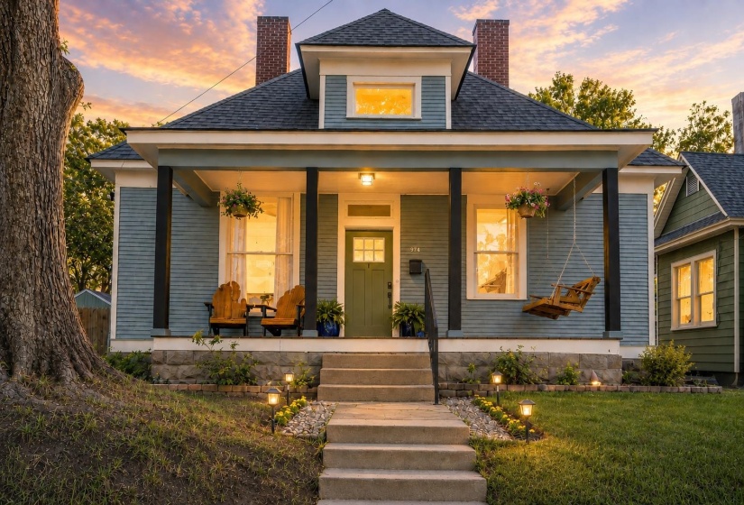 Craftsman-style home featuring a covered front porch, a dark green entry door, and exterior sconce lighting