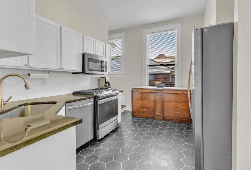 Kitchen featuring hexagonal tile flooring, white cabinetry, and stone countertops