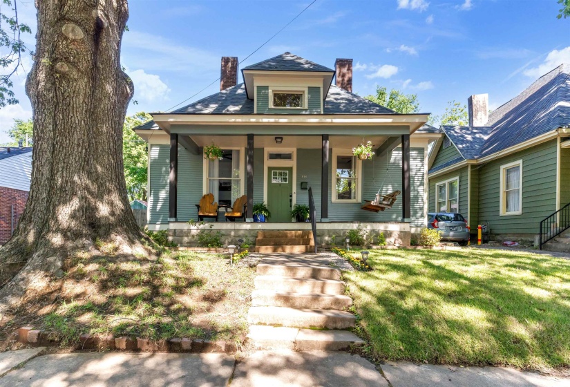 Craftsman-style home featuring a covered front porch, a vibrant green front door, and a prominent dormer window