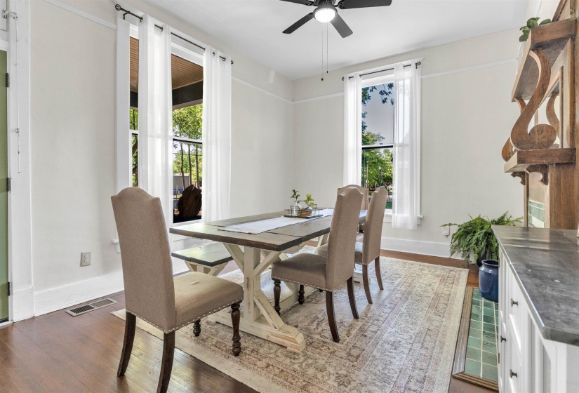 Dining area featuring wood-finish flooring, a ceiling fan, and multiple windows