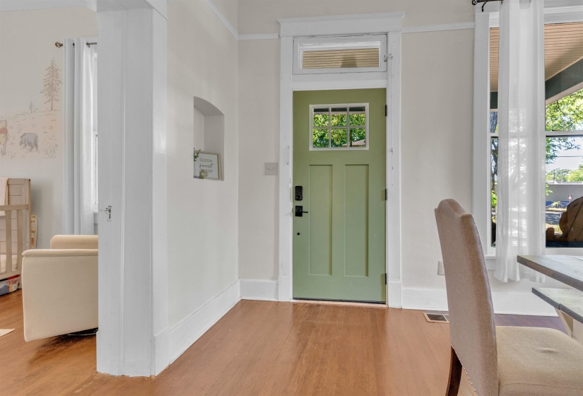 Entryway featuring a paneled door with window inserts, transom window, and wood-finish flooring