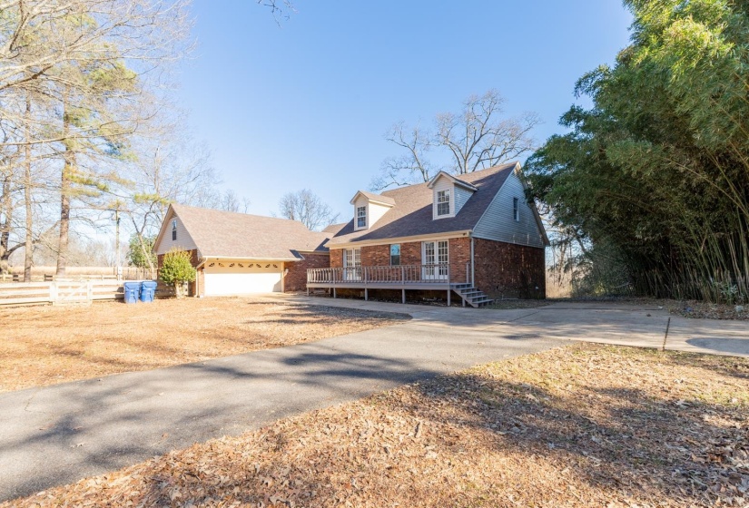 View of front of property with a garage, brick siding, and driveway