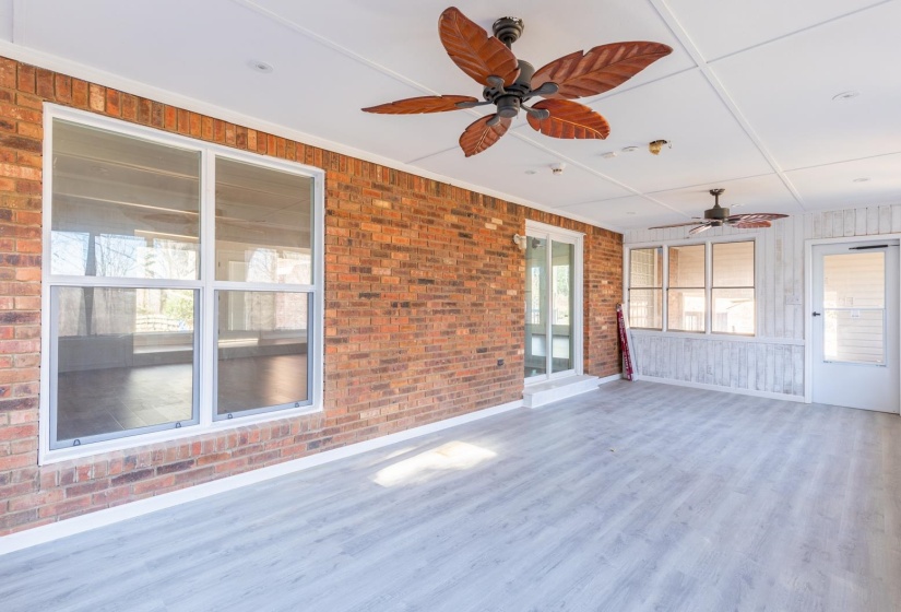 Unfurnished sunroom featuring ceiling fan