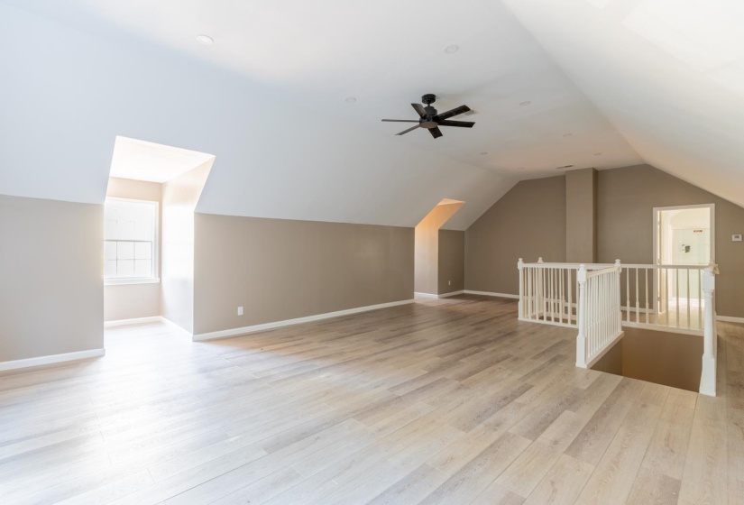 Additional living space featuring vaulted ceiling and light wood-style flooring