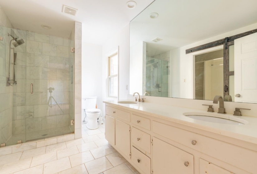 Bathroom with a shower stall, double vanity, light tile patterned floors, and recessed lighting