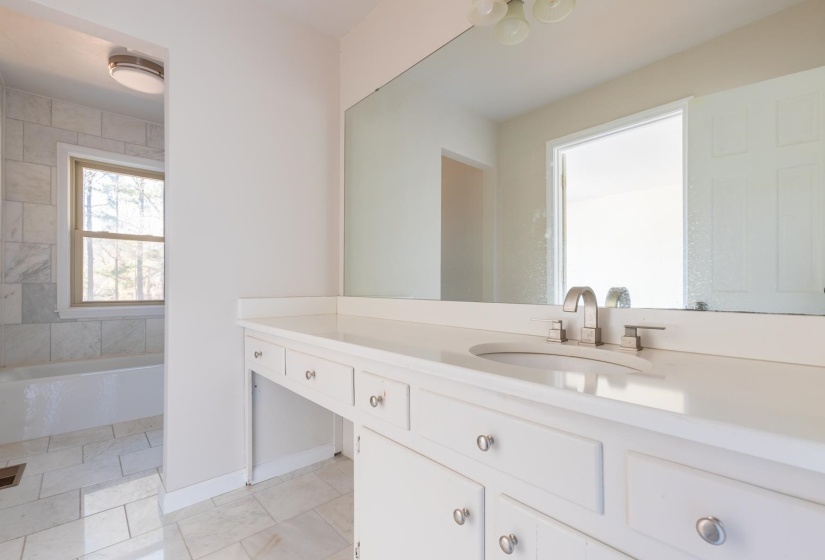 Full bath featuring vanity, washtub / shower combination, and light tile patterned floors