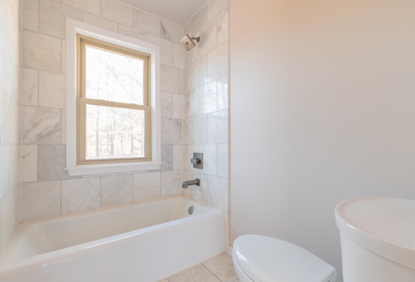 Full bathroom with toilet and shower / bath combination