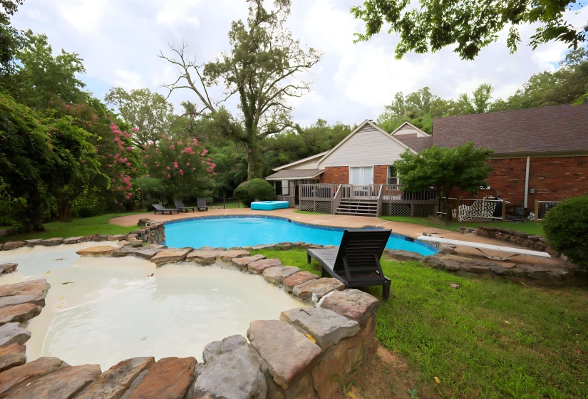 Swimming pool featuring a patio, a yard, an in-ground hot tub, a deck, and view of scattered trees