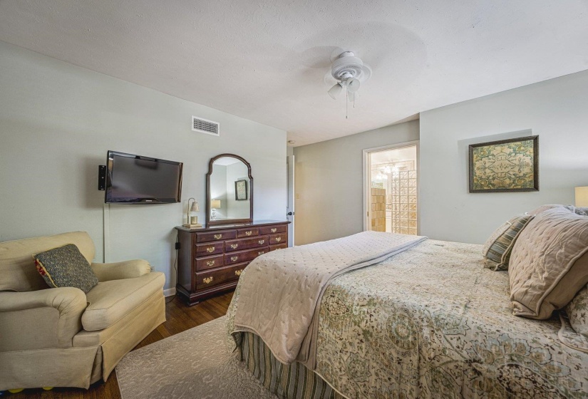 Spacious room featuring wood-finish flooring, a ceiling fan, and a light-colored wall palette