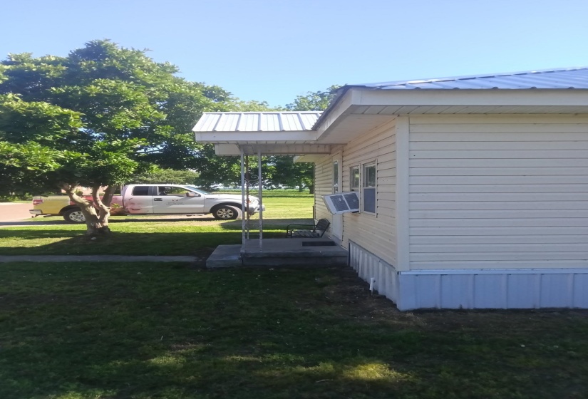 Light-colored siding exterior featuring a white metal roof