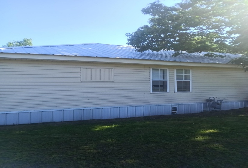 Exterior siding in a neutral tone with a metal roof
