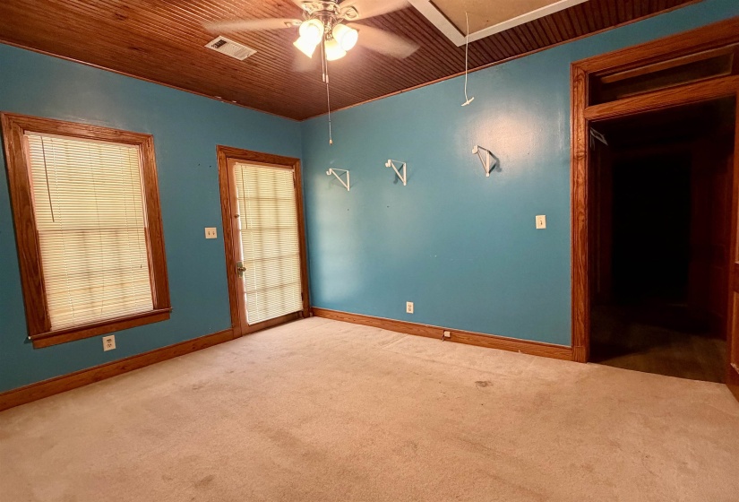 Room featuring beadboard wood-finish ceiling, wood-trimmed windows, a wood-trimmed door with frosted glass, and wood-trimmed baseboards