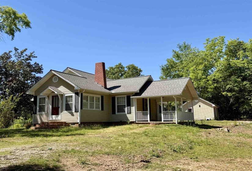 Single-story residence featuring light-toned siding, a covered front porch, and a side porch with white railings