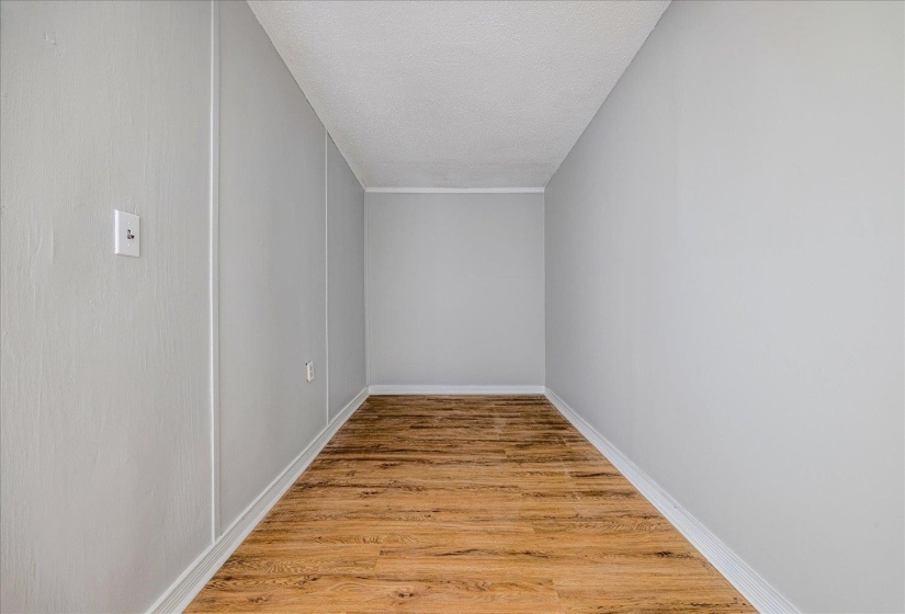 Additional living space featuring light wood-style flooring and a textured ceiling