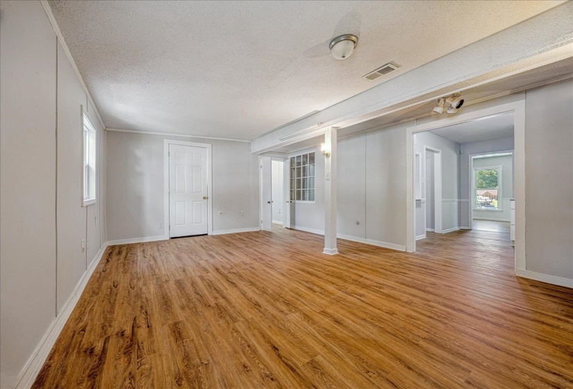 Unfurnished living room featuring light wood-type flooring and a textured ceiling