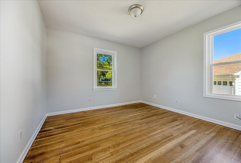 Empty room featuring wood finished floors and plenty of natural light