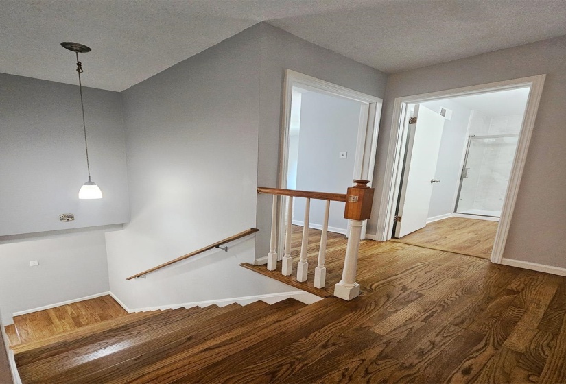 Stairs featuring wood finished floors and a textured ceiling