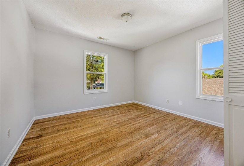 Empty room featuring light wood-type flooring and a textured ceiling