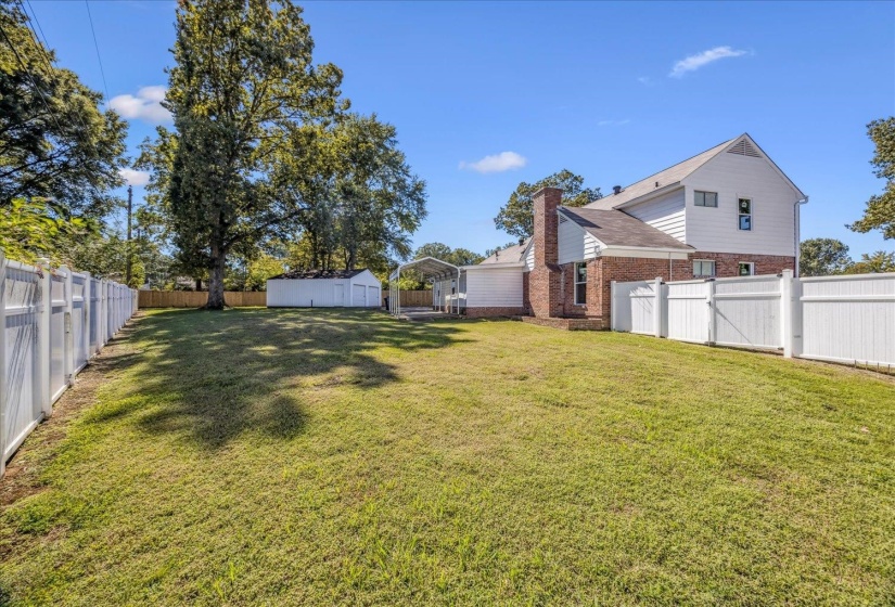 Fenced backyard with a detached carport and a storage unit