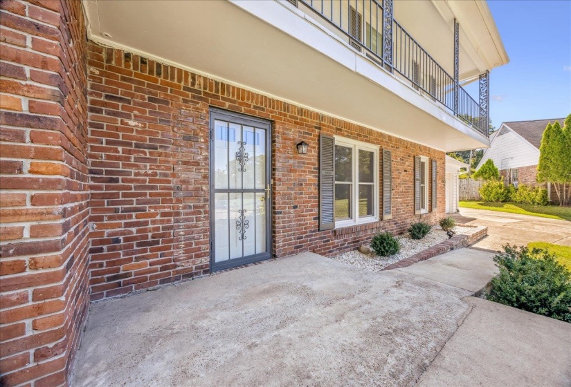 Doorway to property with brick siding and a patio