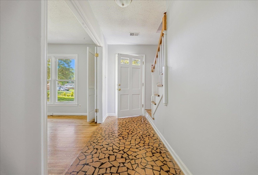 Doorway featuring a textured ceiling, wood finished floors, and stairs