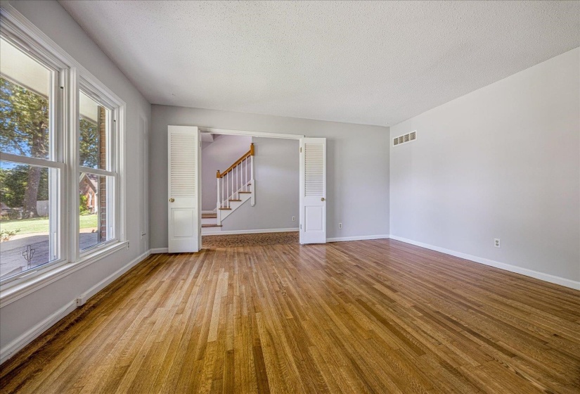 Unfurnished room featuring stairway, wood finished floors, and a textured ceiling