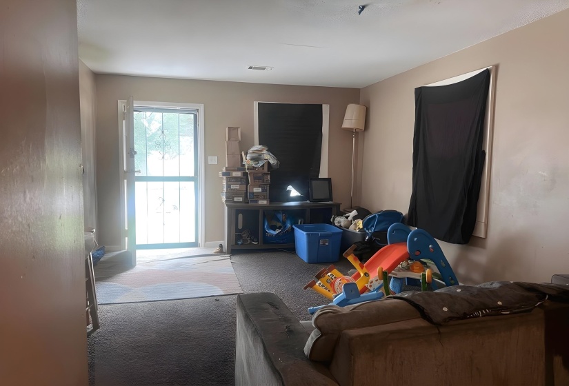 Entry door with security screen, carpeted flooring, and neutral wall paint
