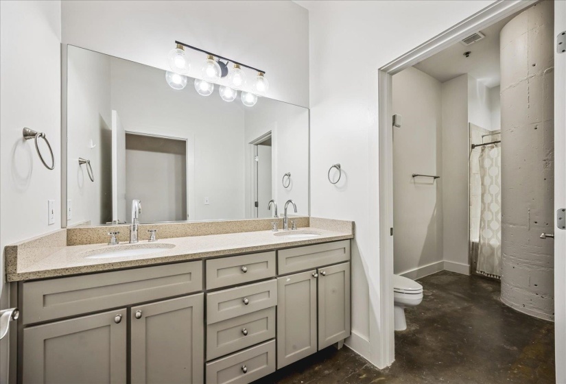 Dual vanity with light-colored countertop, recessed sinks, and gray cabinetry